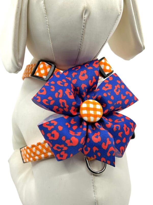 An Orange Check w/ Optional Team Bow Choices- "H" Style Harness and blue dog harness with a flower on it.