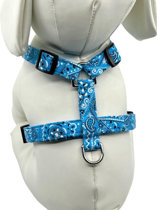 A blue bandana dog harness on a white teddy bear.
