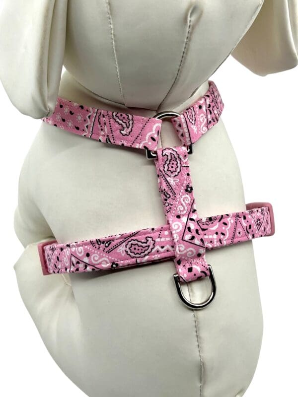 A dog wearing a pink bandana harness.