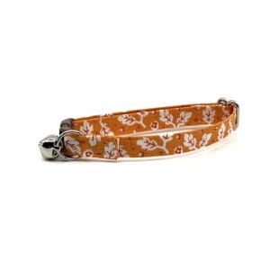 A cat collar with an orange and white floral pattern.