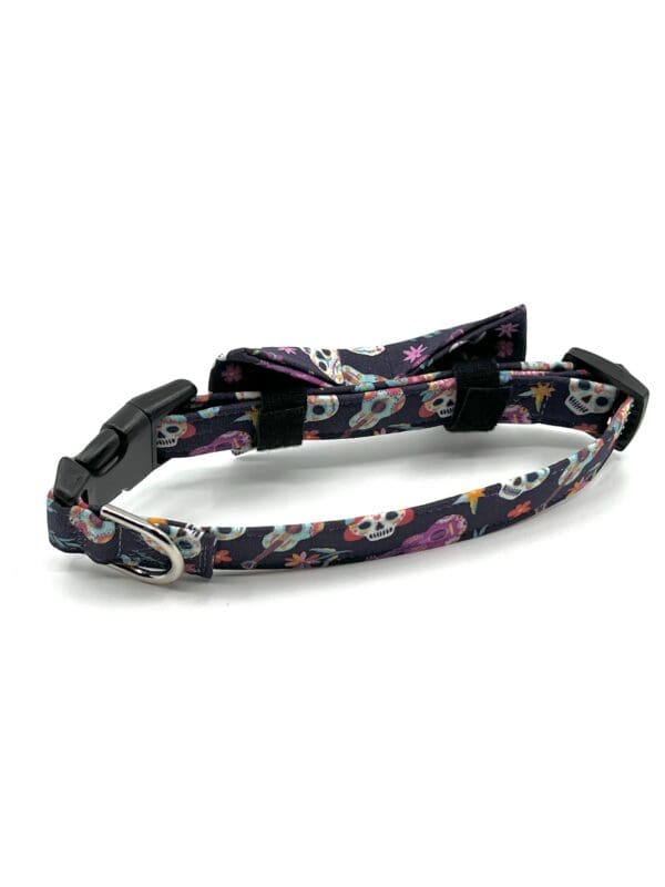 A dog collar with skulls and flowers on it.