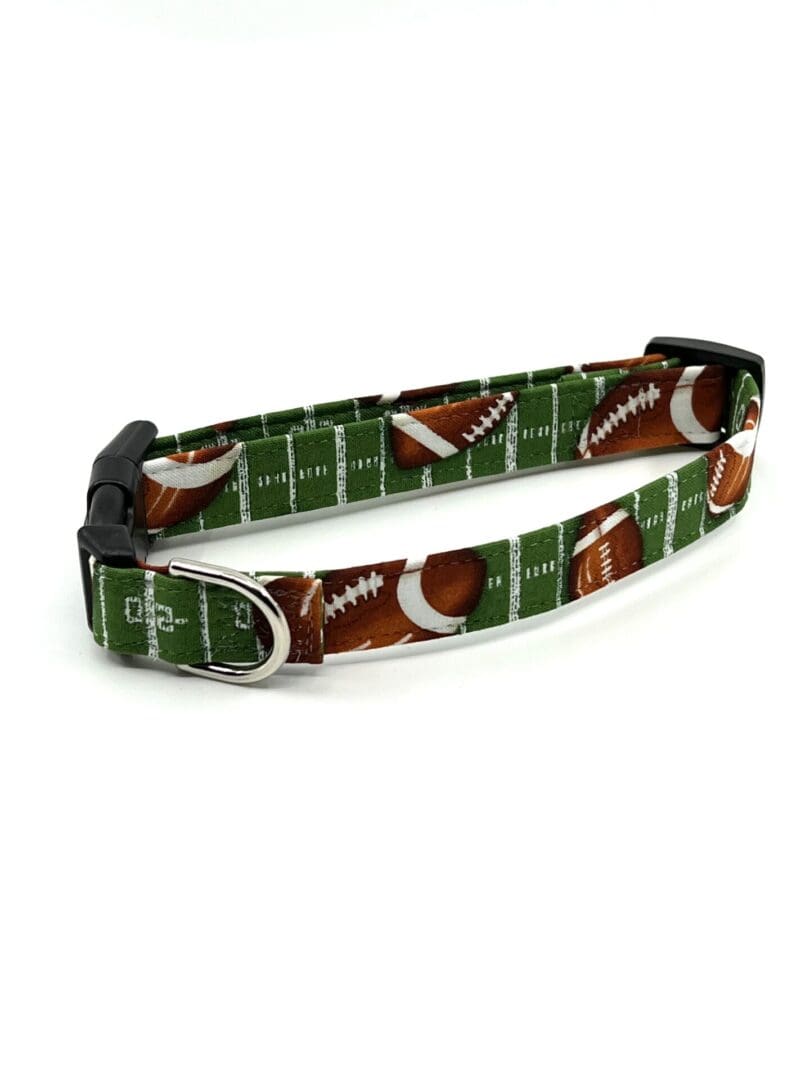 A green dog collar with footballs on it.