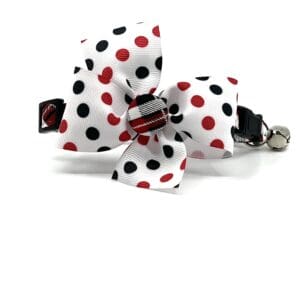 A white and black polka dot bow with red and black stripes.