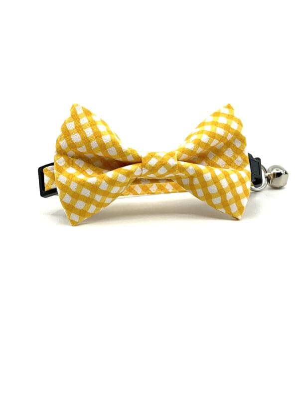 A yellow and white gingham bow tie on a white background.