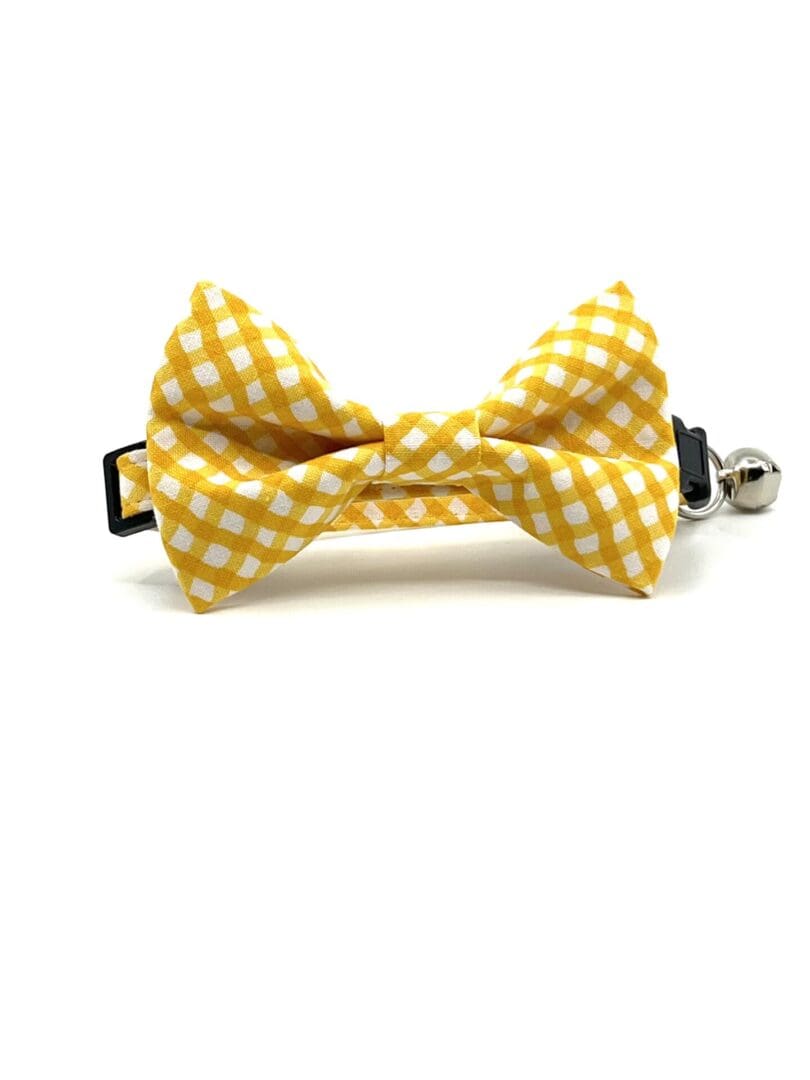 A yellow and white gingham bow tie on a white background.