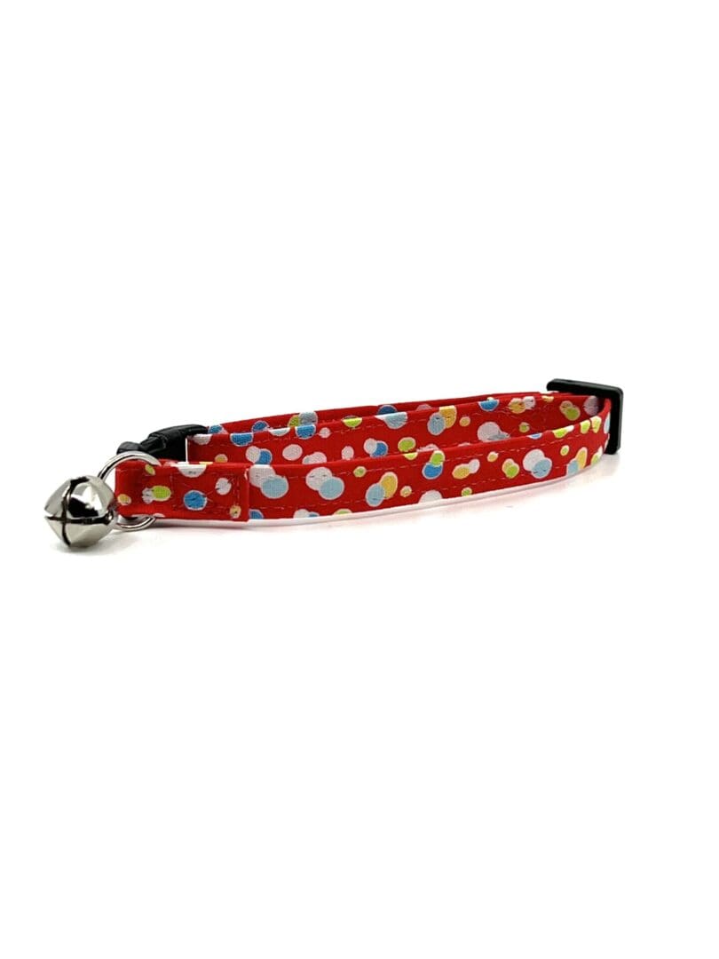 A red cat collar with polka dots on it.
