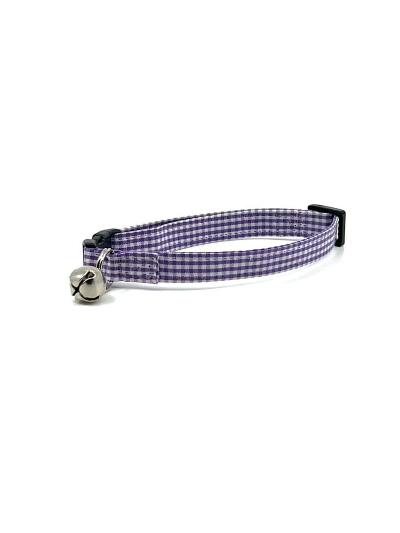 A purple and white plaid cat collar with a bell.