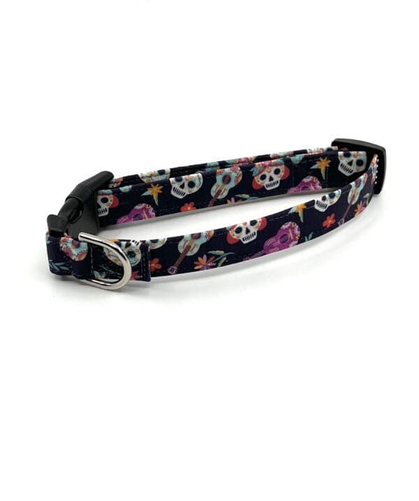 A dog collar with skulls and flowers on it.