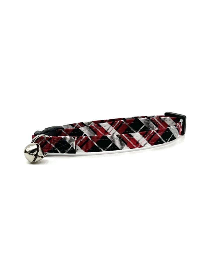 A black and red plaid cat collar with a bell.