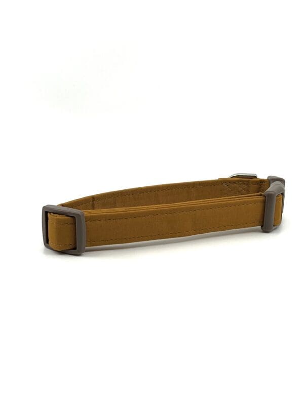 A brown dog collar with a black buckle.