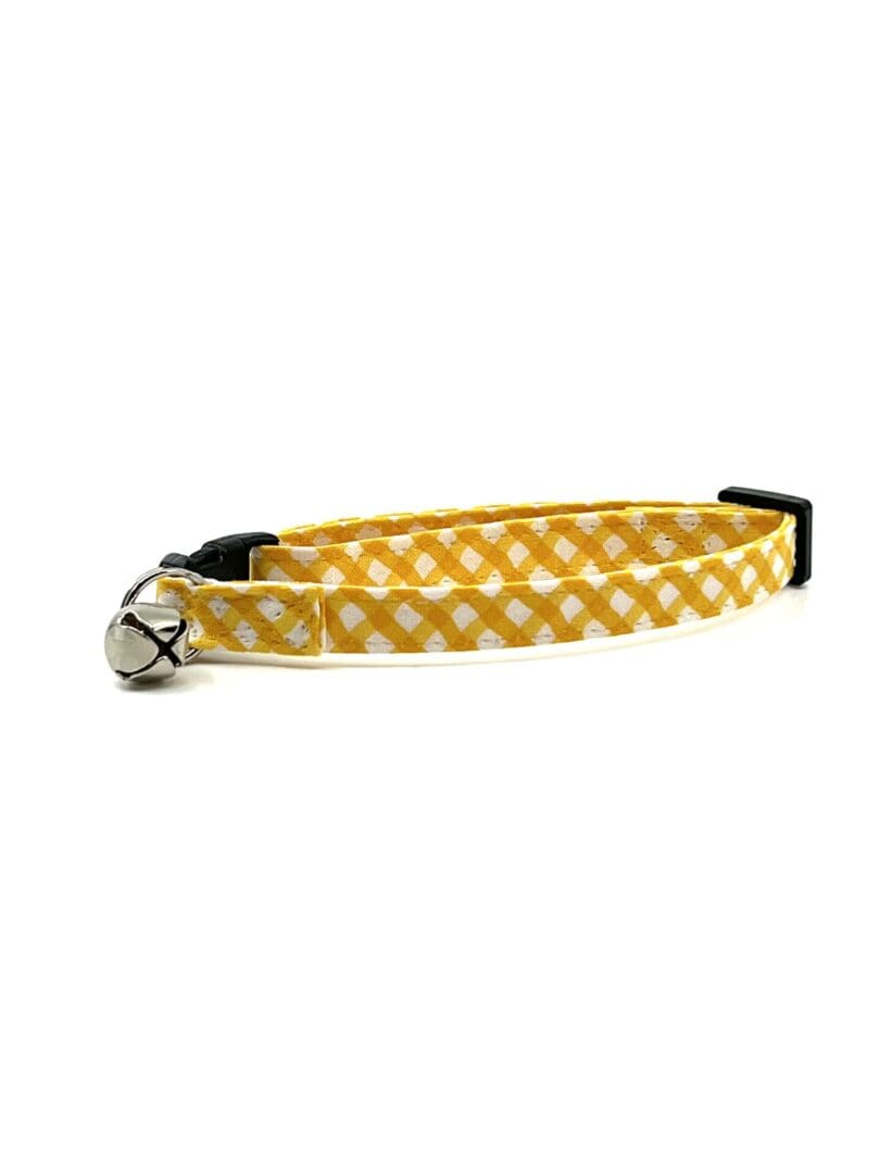 A yellow and white cat collar with a black buckle.