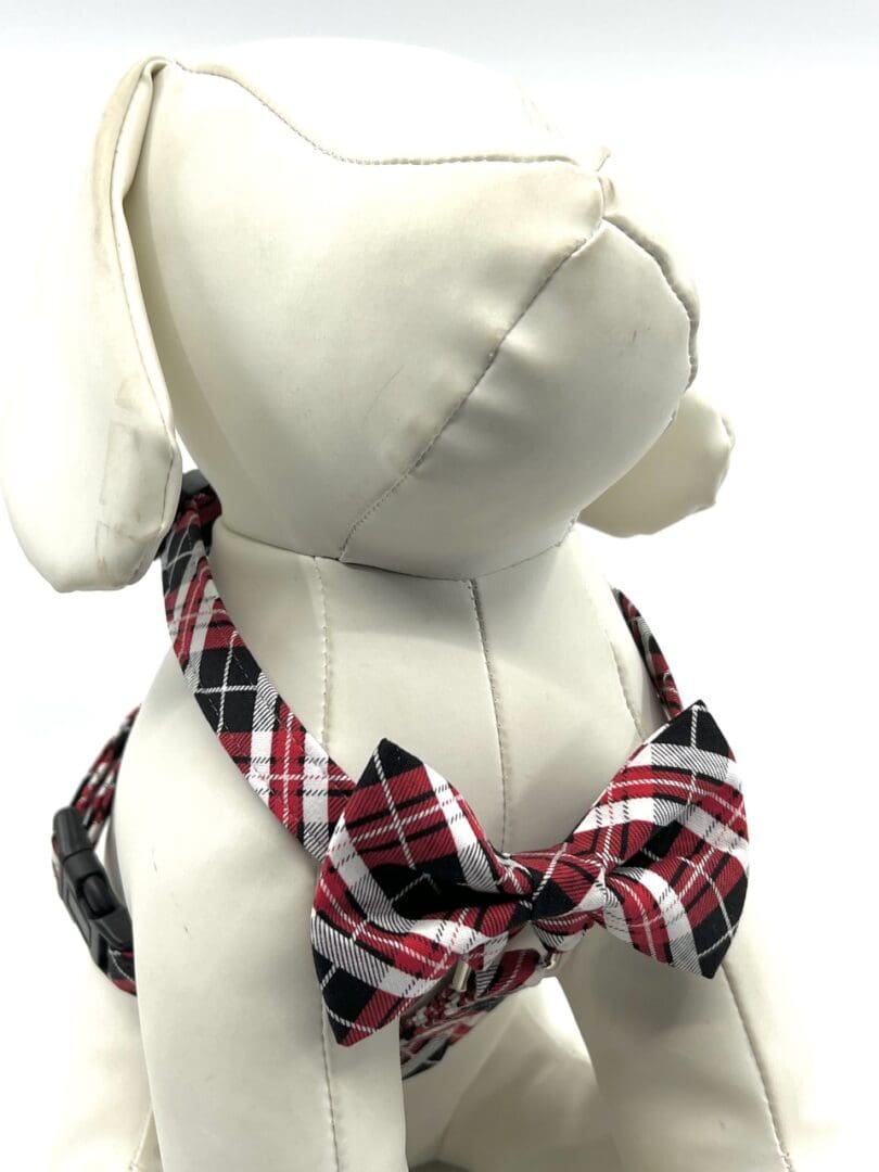 A stuffed dog wearing a red and black plaid collar.