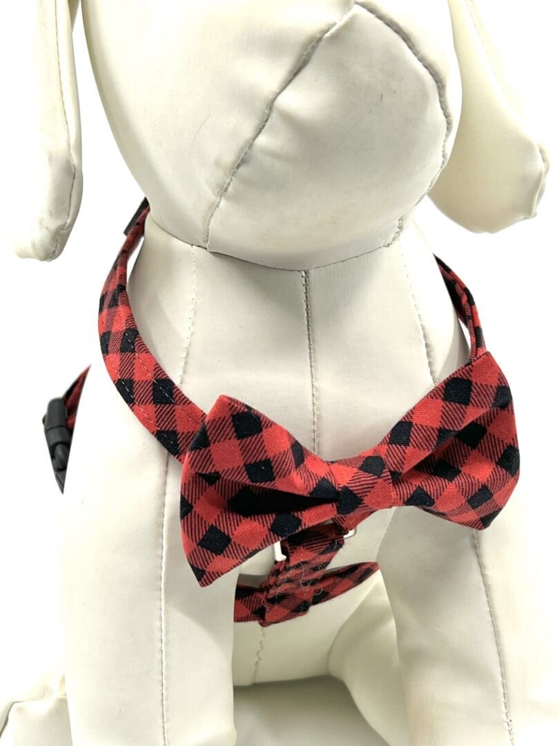 A dog wearing a red and black bow tie.