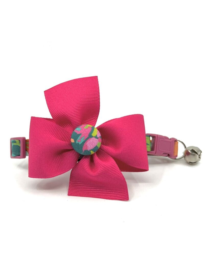 A pink bow with a button on it