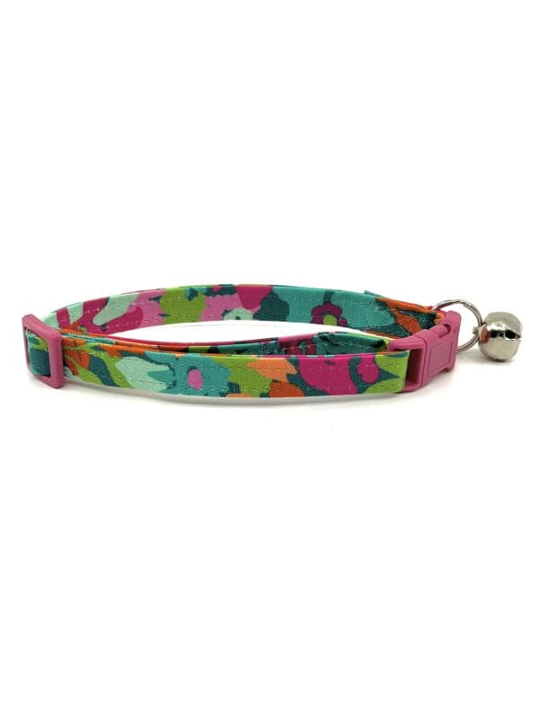 A cat collar with a bell on top of it.