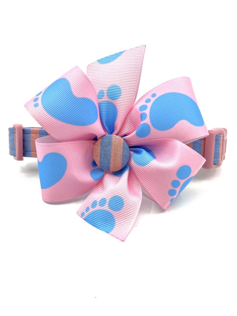 A pink and blue bow with footprints on it.