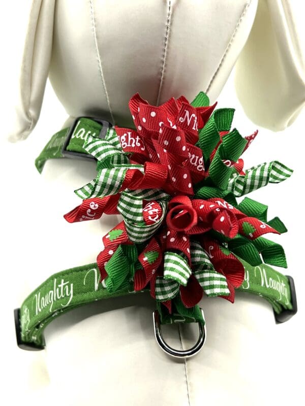 A dog harness with red and green ribbons.