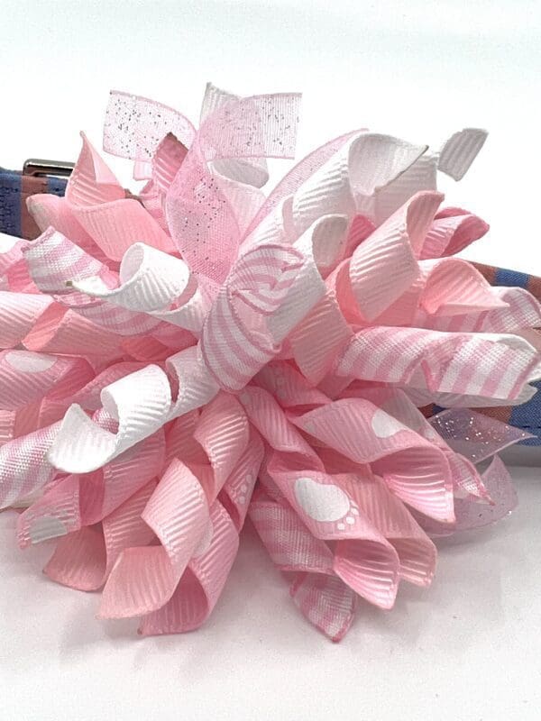 A pink and white bow on top of a table.