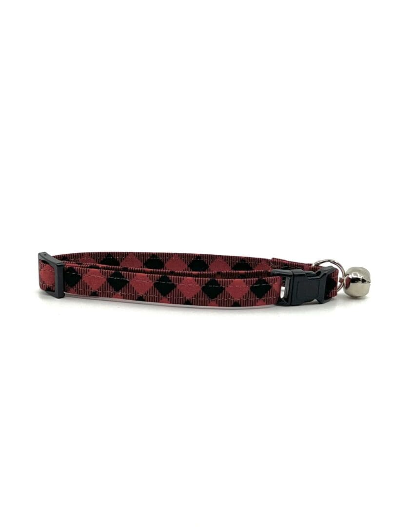 A red and black checkered cat collar with bell.