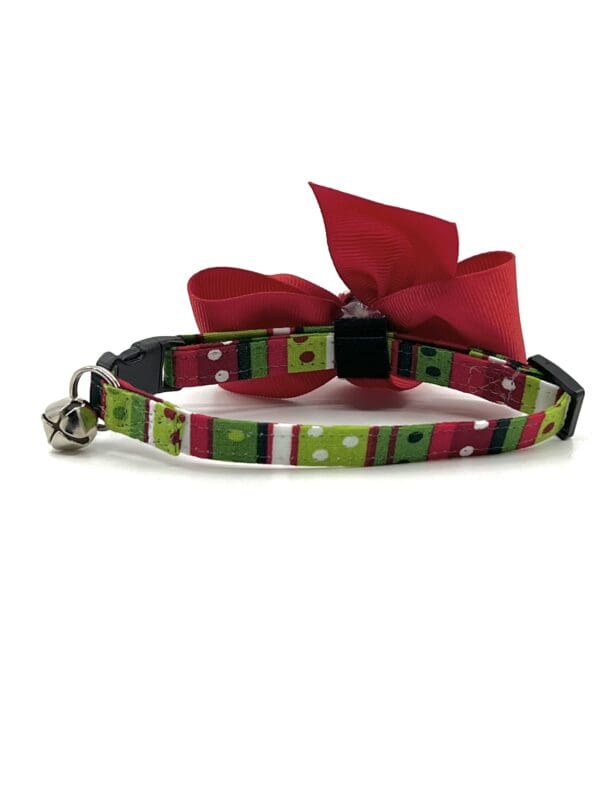 A cat collar with a bow and bell.