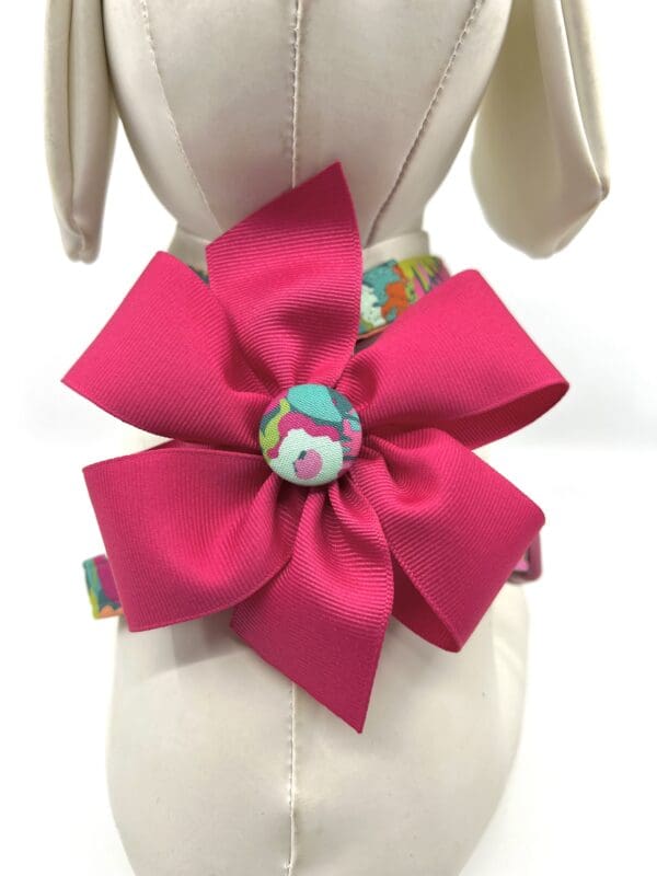 A pink bow is on the back of a dress.