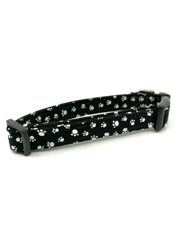 A black and white dog collar with skulls on it.