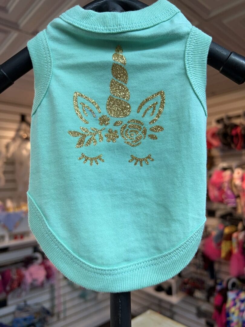 A light blue tank top with a gold design on it.