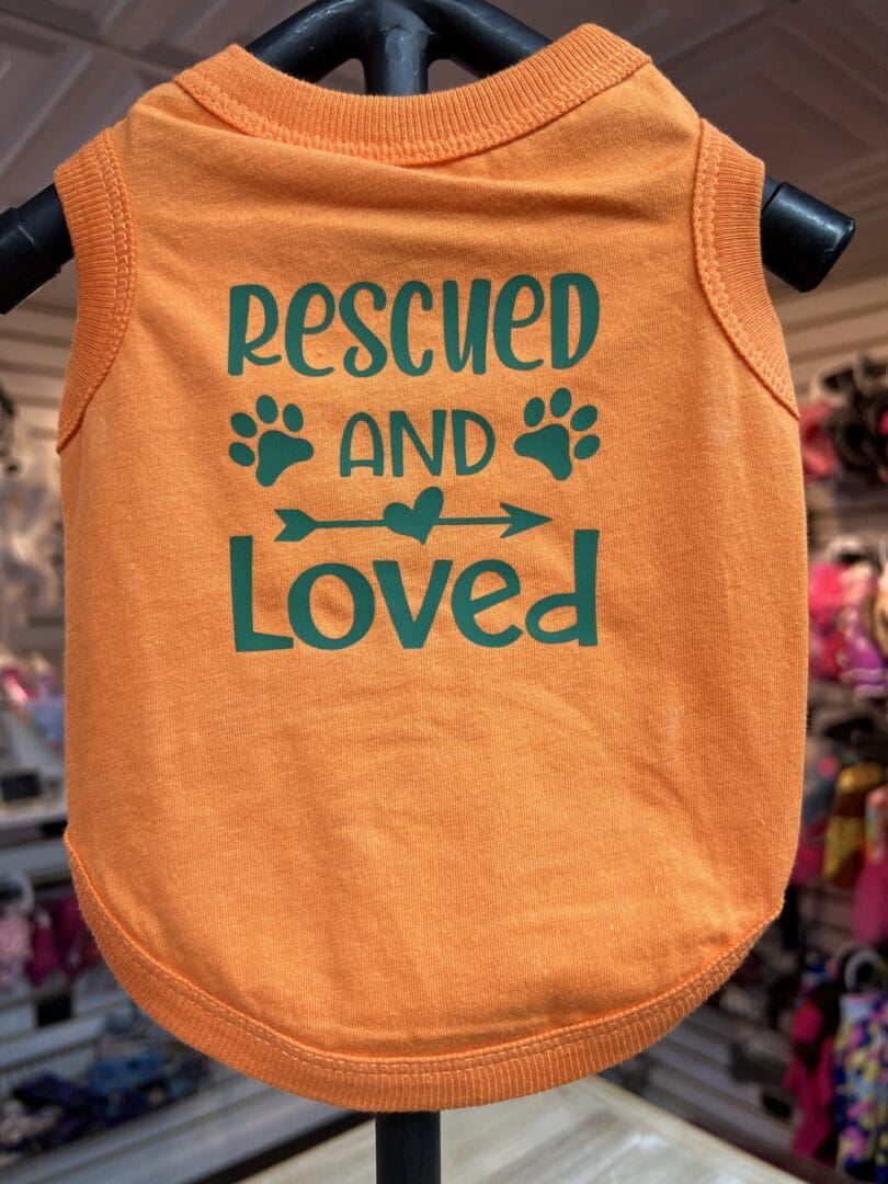 A dog shirt that says " rescued and loved ".