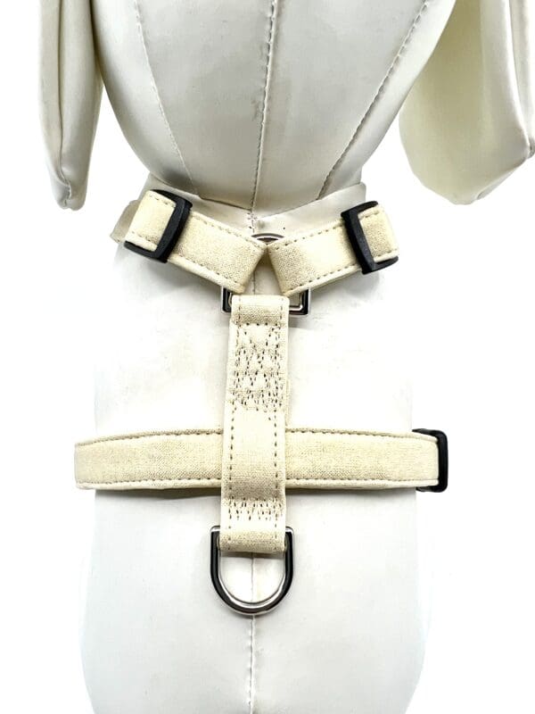 A white harness with black stitching on the front of it.