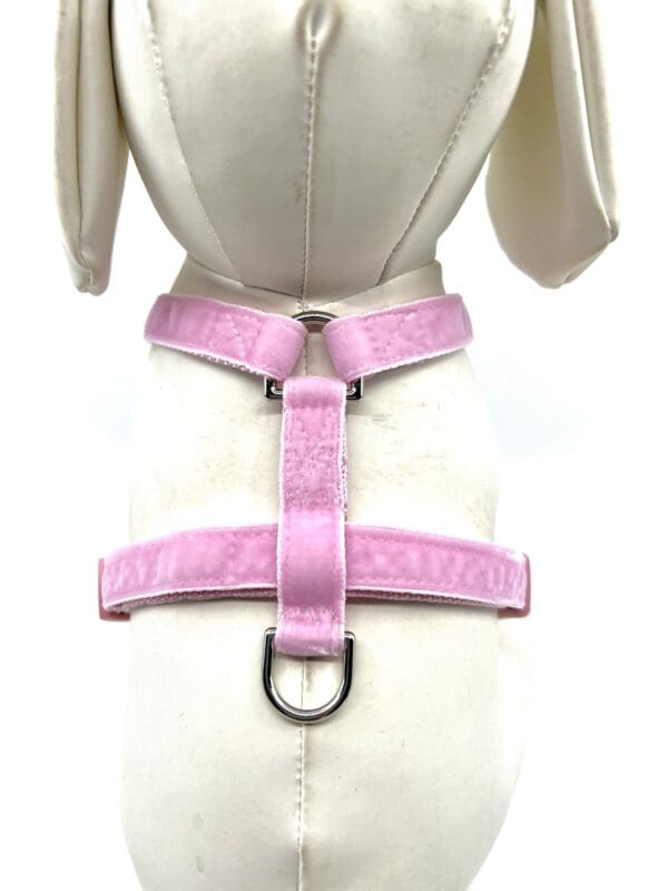 A pink dog harness on a mannequin torso.