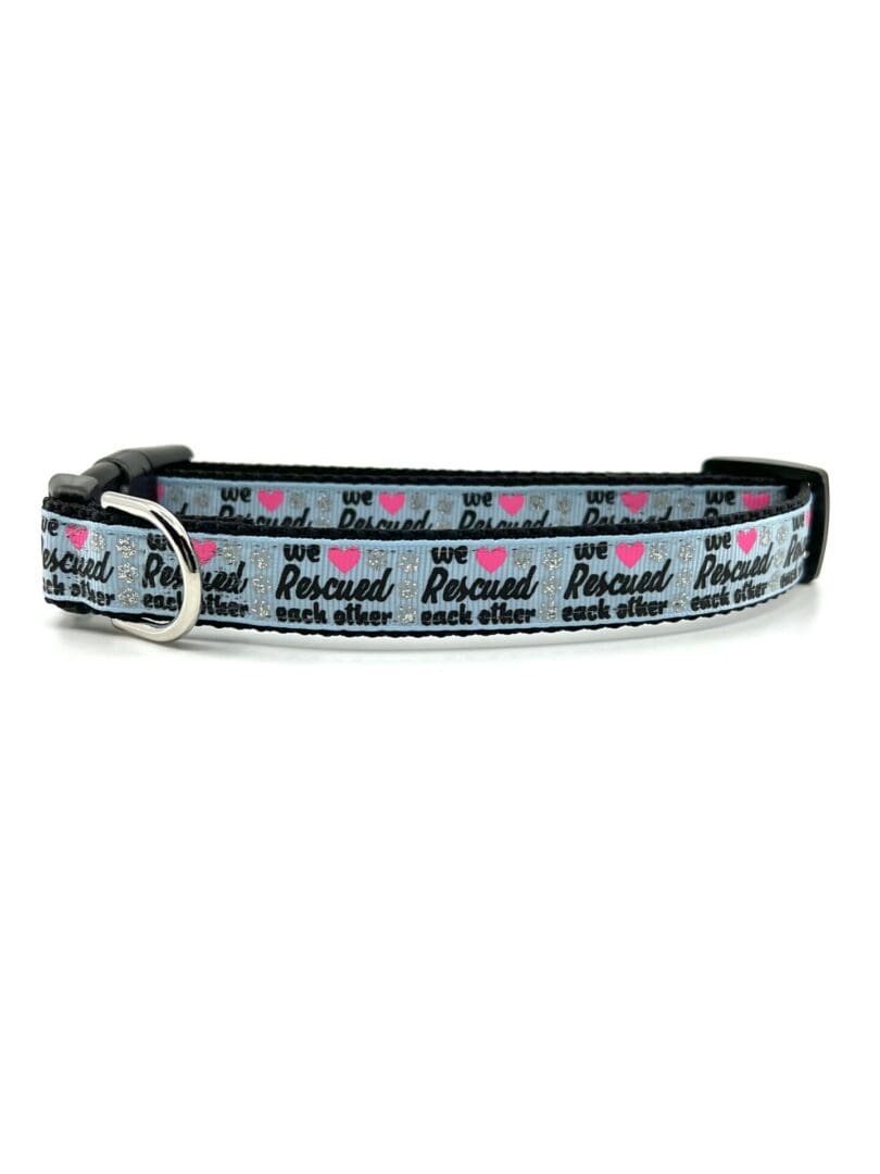 A gray dog collar with pink hearts on it.