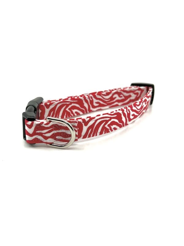 A red and white dog collar with a black buckle.