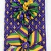 A purple, green and yellow bow on top of a gift bag.