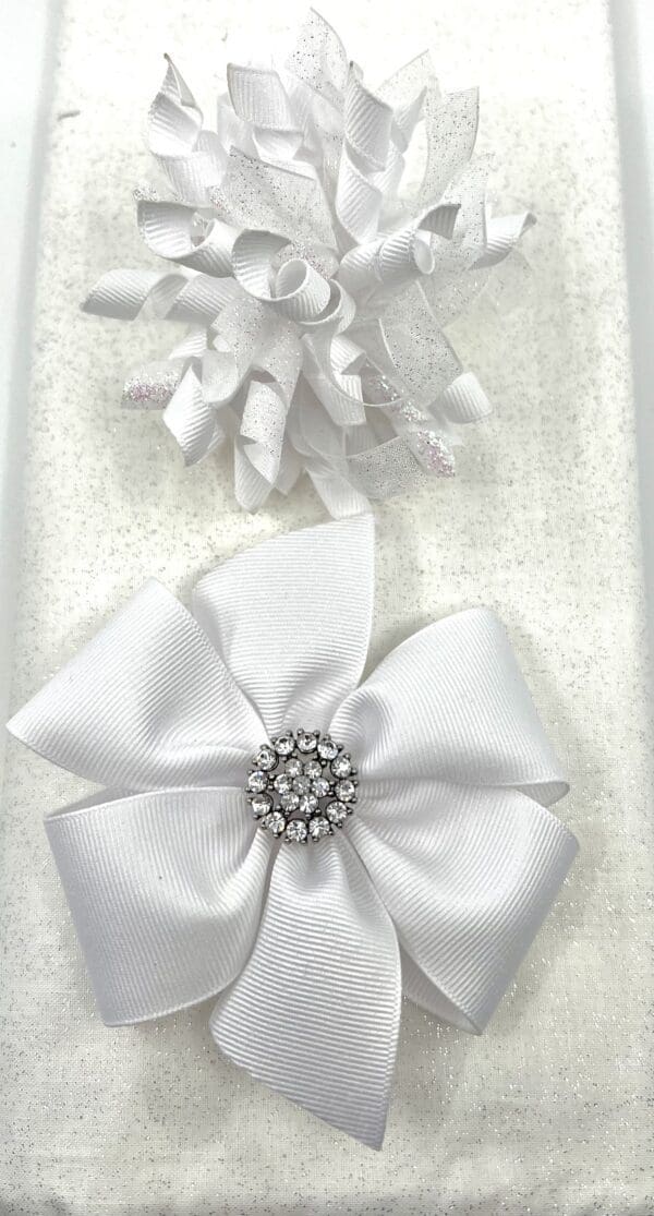 A white bow and some ribbons on top of a table.