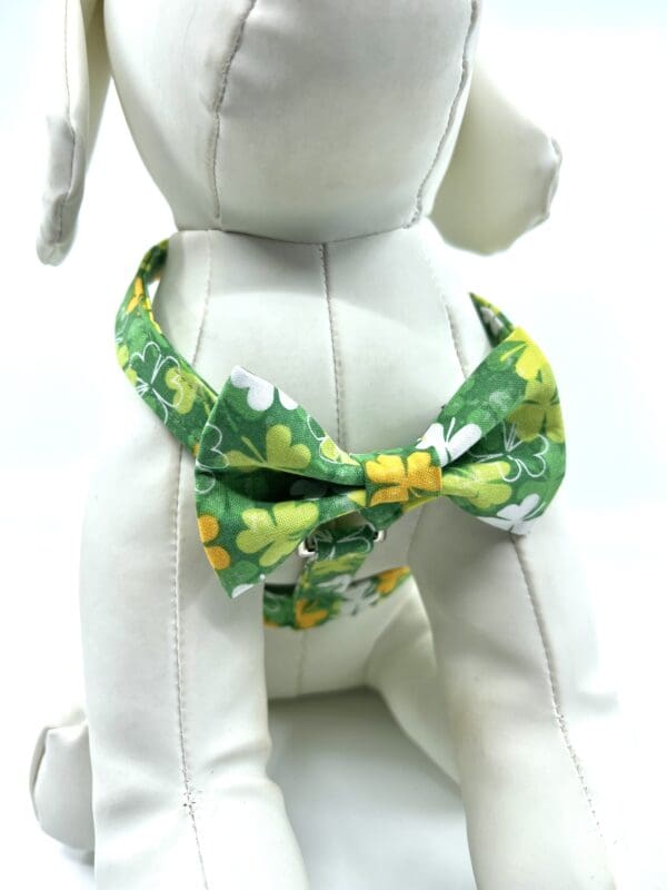 A dog wearing a bow tie with green and yellow flowers.