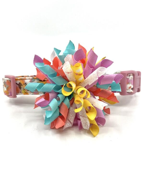 A colorful flower is attached to the end of a dog collar.