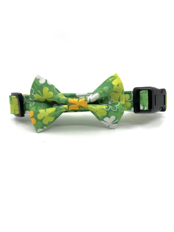 A green bow tie with yellow and white flowers.