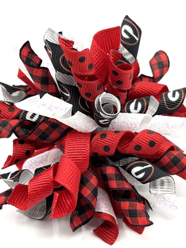 A close up of the top of a red and black bow