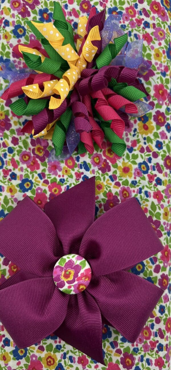 A purple bow on top of a floral wrapping paper.