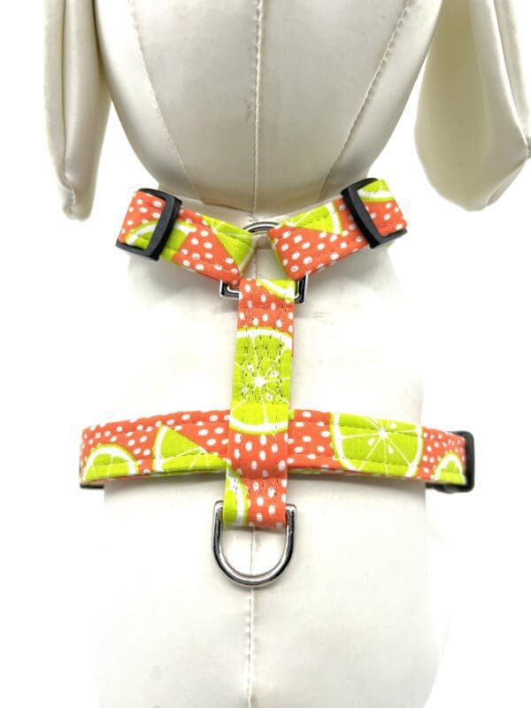 A dog harness with lime and polka dots on it.
