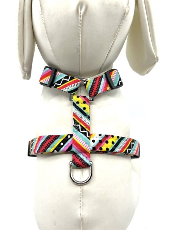 A dog harness with colorful stripes and dots.