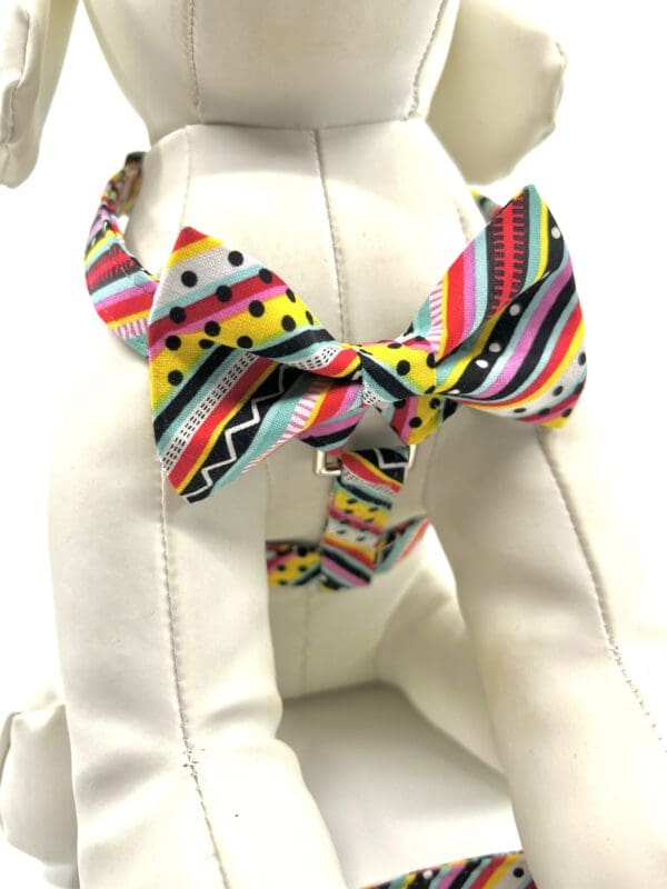 A dog wearing a colorful bow tie.