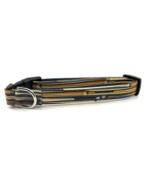 A brown and black striped dog collar with metal hardware.