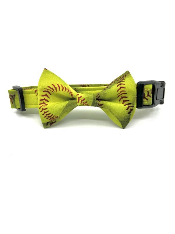 A yellow bow tie with softballs on it.