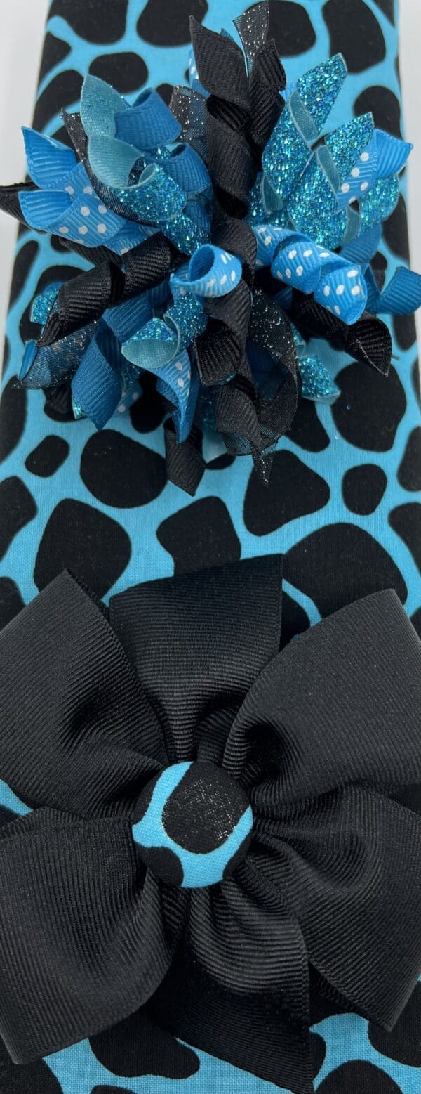 A close up of the bow on a blue and black animal print shoe.