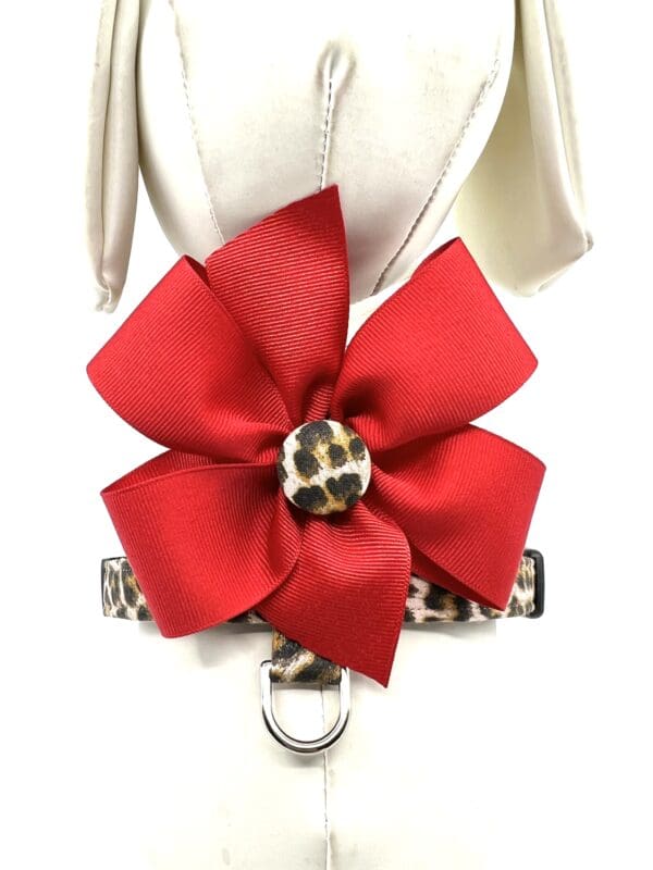 A red bow on the back of a leopard print dog collar.