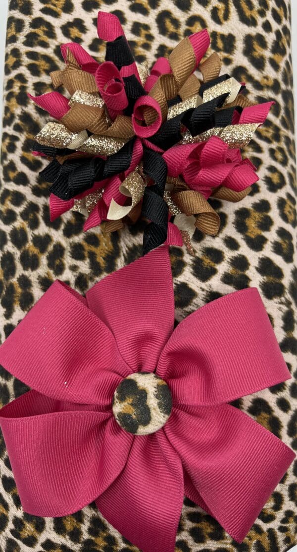 A leopard print bag with a pink and black bow.