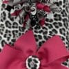 A close up of two bows on top of a leopard print blanket.