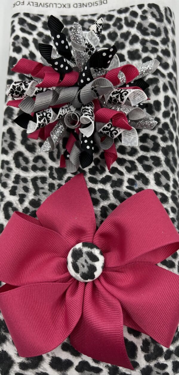 A close up of two bows on top of a leopard print blanket.
