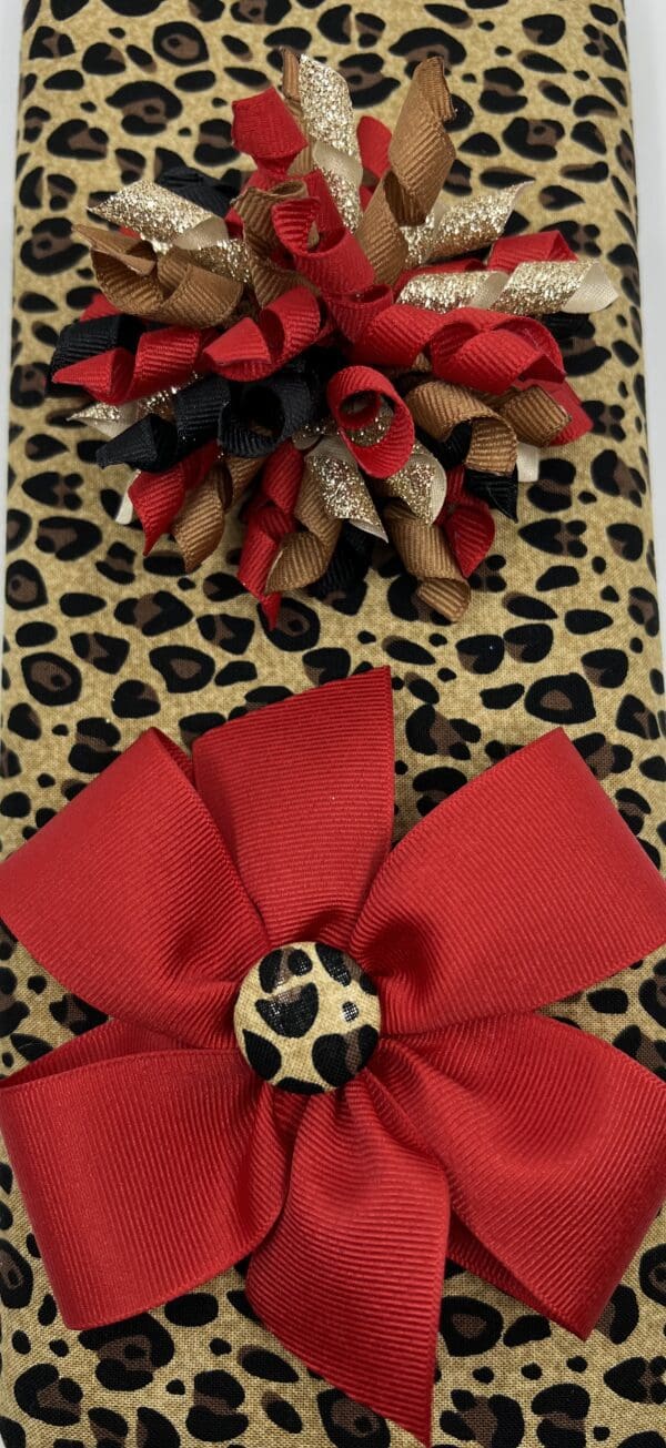A leopard print bag with red bow and flower.
